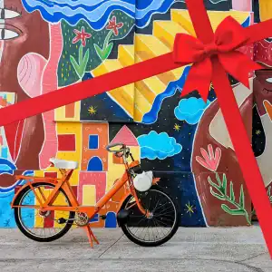 Solex garé devant une fresque très colorée de l’artiste Axelle Sodade dans une rue du village d’Argelès-sur-Mer