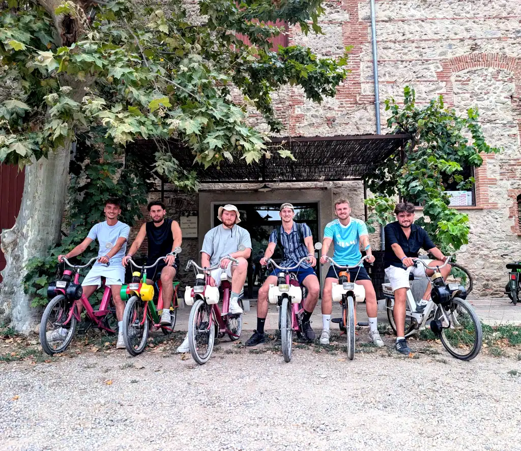 Groupe d’amis en Solex posant devant le caveau du domaine de Villeclare avant une dégustation de vins locaux